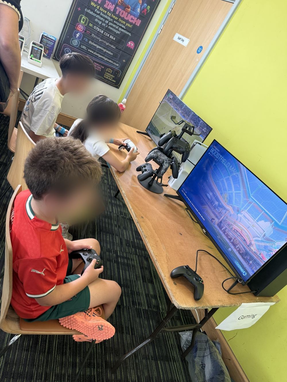 A child in a red top playing a console game at a Pixcade party